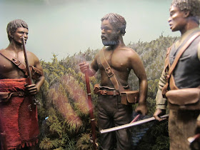 Diorama of 19th-century Maori with muskets in the bush.