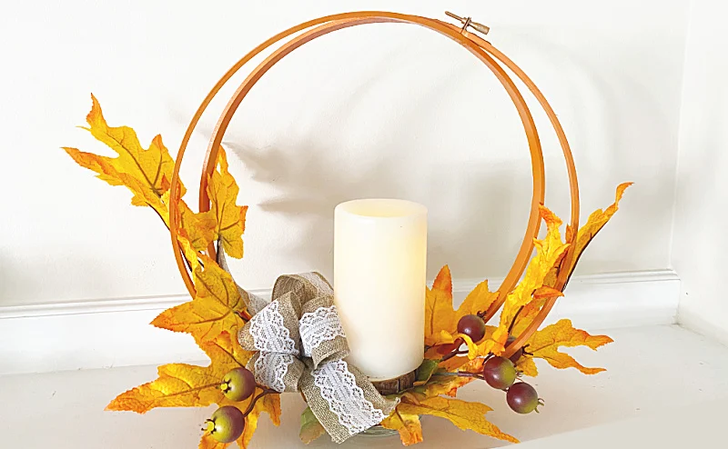 embroidery hoop centerpiece with leaves and a candle