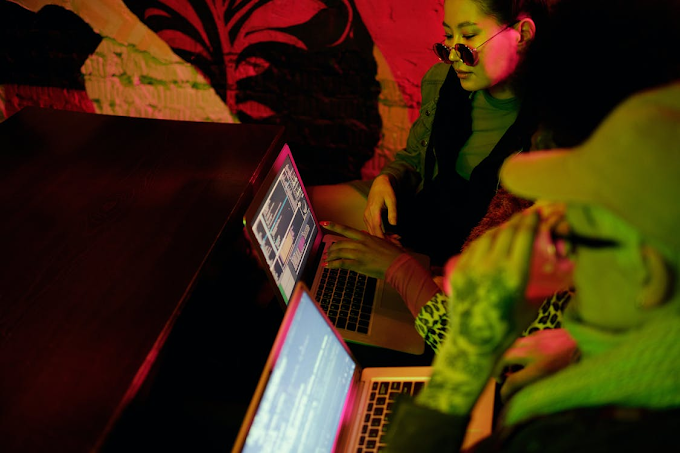 Três mulheres programando em dois laptops