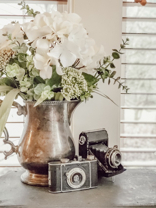White hydrangea bouquet in a vintage silver pitcher