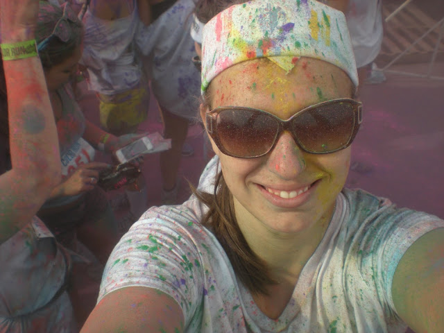 Woman smiling and taking a selfie during a color run