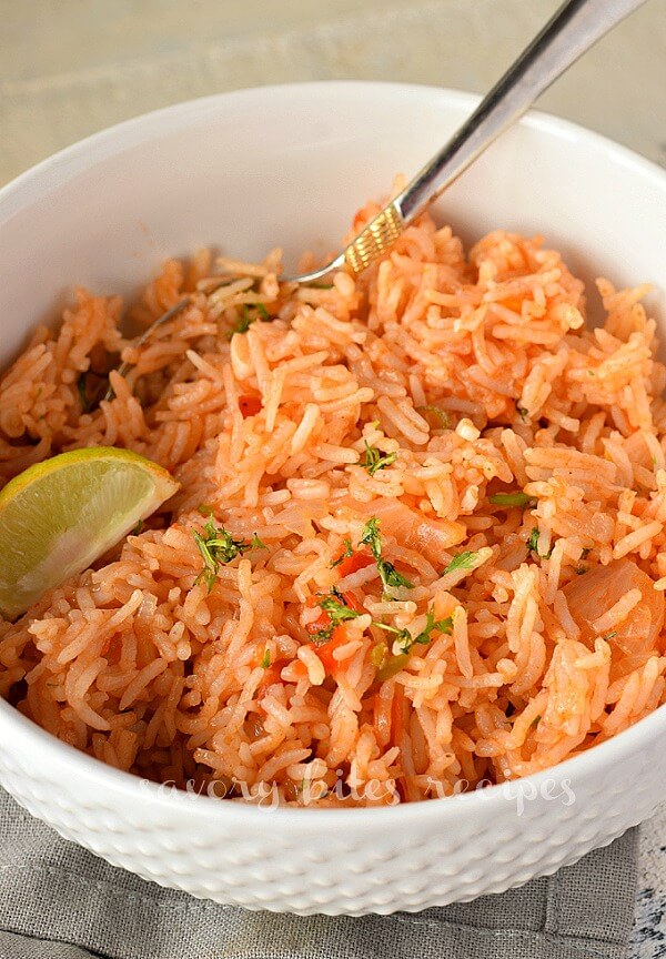 a white bowl with mexican rice topped with chopped cilantro