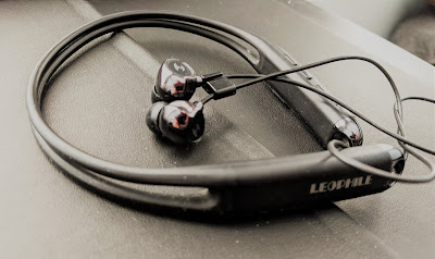 A pair of earbuds connected by a black chord.