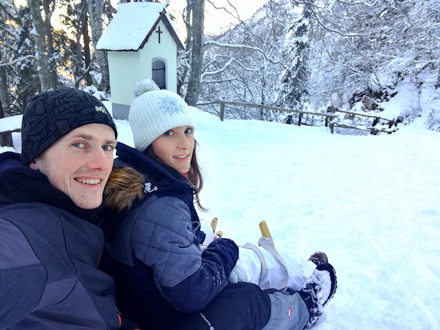 Ljubelj sankanje: moški in ženska na sankah v zasneženi pokrajini