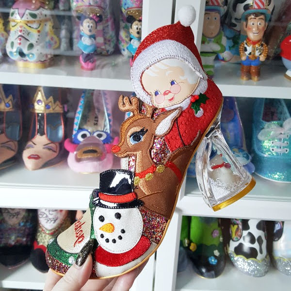 side of Christmas character shoe in front of shoe shelves, held in hand