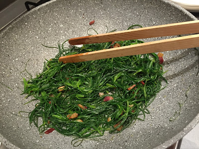 A sauté of agretti in one of those teflon free, stone finish-looking pans that are all the rage here in Italy.