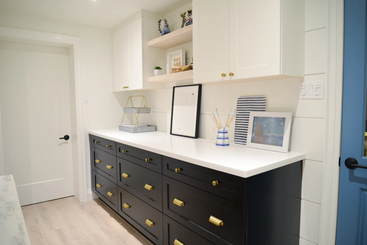 modern coastal craft room with home depot cabinetry, white walls, craft table, shiplap walls, coastal decor