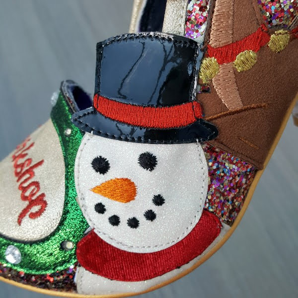 close up of applique snowman with black patent hat on side of shoe