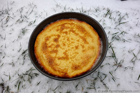 image of a Finnish Oven Pancake in a round cake pan on a snowy lawn