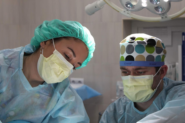Medical Tourism in India two surgeons with face mask on performing surgery on a patient in operation theatre