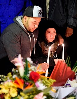 Mourners light a candle for the deceased policemen Ramos and Liu