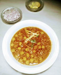 Serving chole(chickpeas curry) with chopped onion and lemon wedges for chole chickpeas recipe