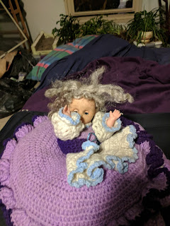 Doll with grey hair and purple and whtie crocheted dress
