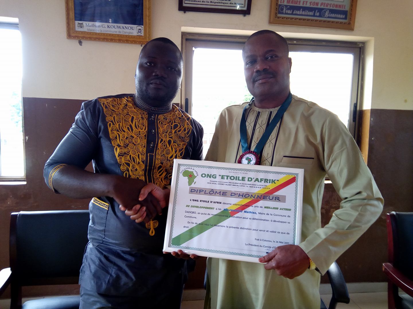 Mathias G. Kouwanou recevant sa distinction des mains de Mohamed Badélé, Pdt de l'Ong Etoile d'Afrik