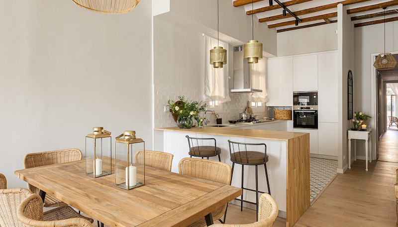 La reforma integral de un encantador piso de 90 metros Cocina con barra de madera abierta al salón