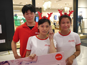 two young women wearing deer antlers and one young man at a Coca-Cola promotion in Bengbu, China