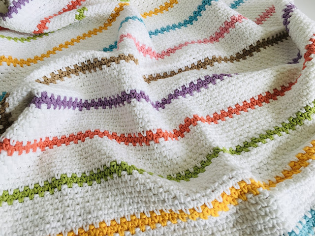A colourful striped crochet baby blanket