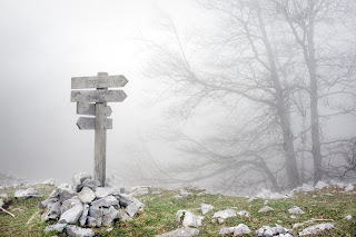 Signpost on a ridge in the fog.