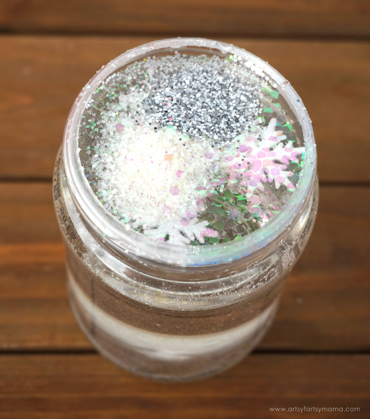 Upcycle a peanut butter jar to create your own DIY Snow Globe winter wonderland!