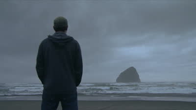 Man+standing+in+rain+at+ocean.jpg