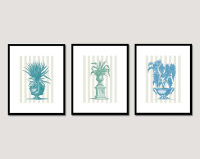 a row of 3 framed images of potted plants in front of wallpaper