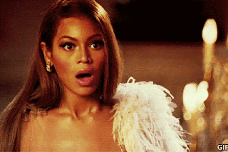 Beyoncé no filme A Pantera Cor de Rosa levando a mão esquerda à boca com cara de quem tá chocadíssima