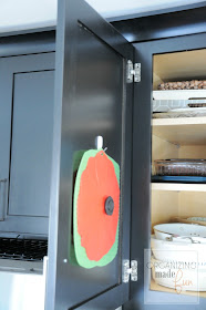 Use wired command hooks to hold rubber lids for serving dishes on back of cabinet door :: OrganizingMadeFun.com