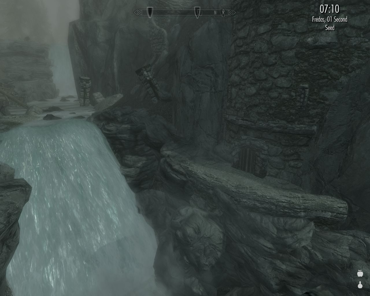waterfall on the left, round stone citadel in the mountainside visible below across the river