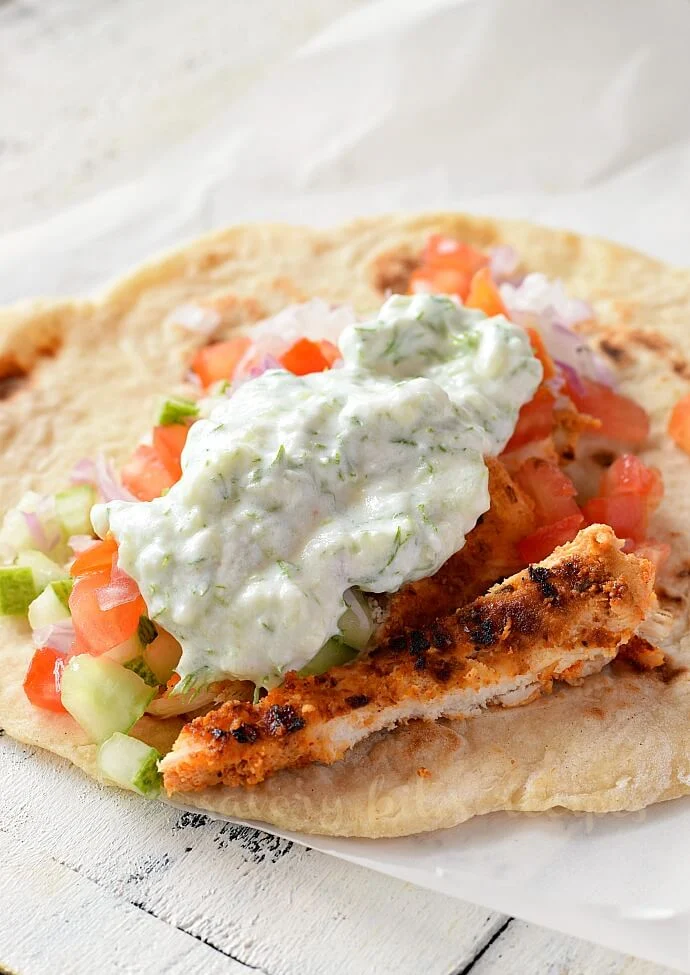 homemade pita bread topped with slaw,shredde chicken and tzatziki sauce