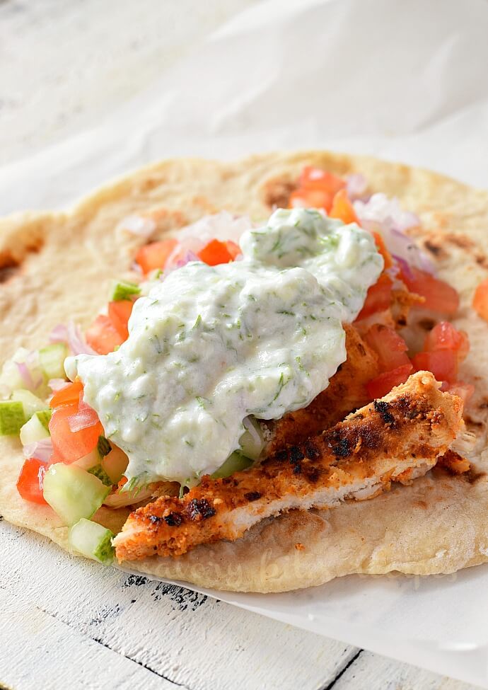 homemade pita bread topped with slaw,shredde chicken and tzatziki sauce