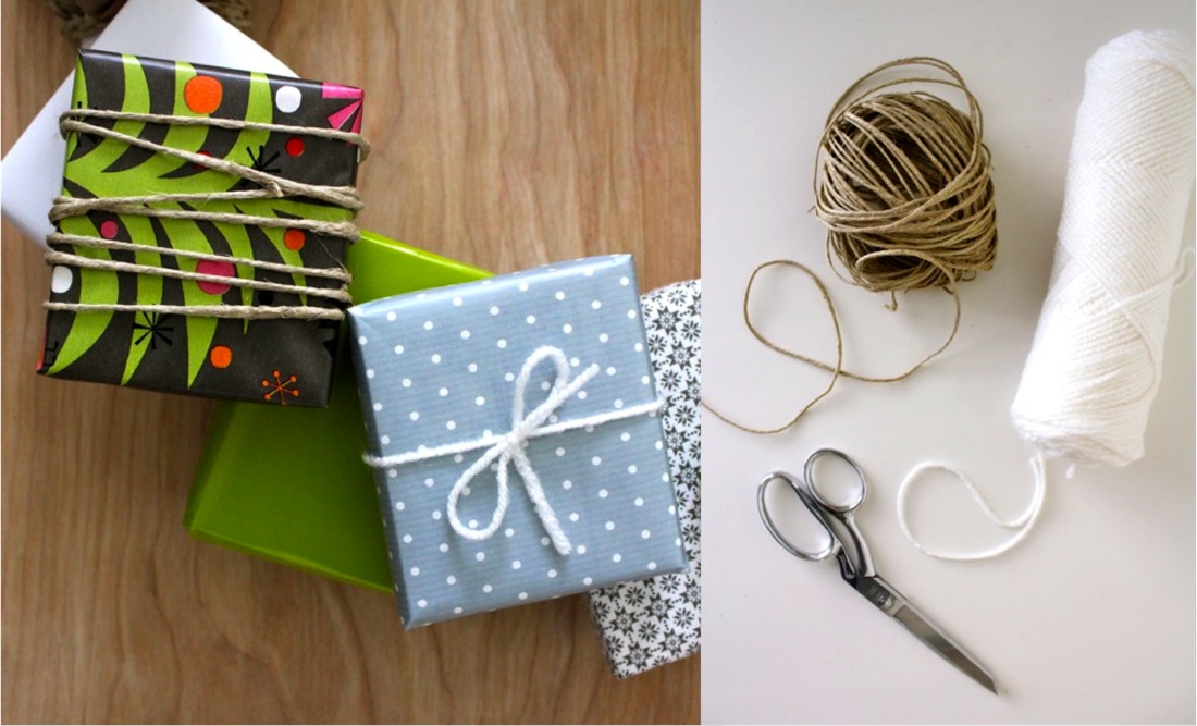 Gift box wrapped in craft paper, ribbon, bow and scissors on white