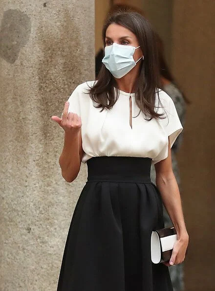 Black high-waist full circle skirt,  black and white heels, Magrit clutch at Board of Trustees of The Cervantes Institute for the year 2020