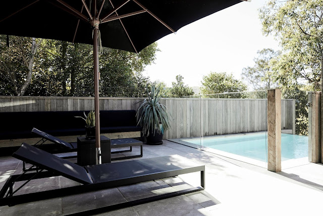 black patio furniture with glass wall surround for pool