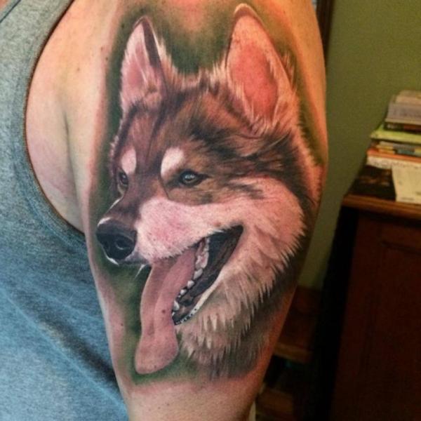 Colorido tatuaje de un huskie en el brazo