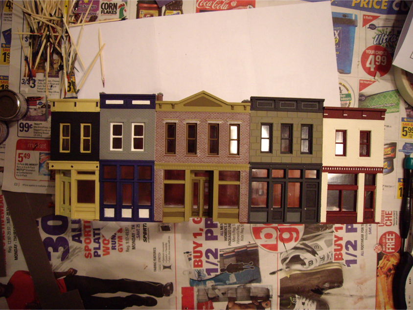 Partially constructed Walthers Merchant’s Row 1 kit with completed paint scheme on store fronts