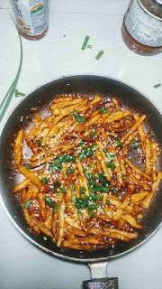 Garnished honey chilli potato in a pan for Crispy honey chilli potato recipe