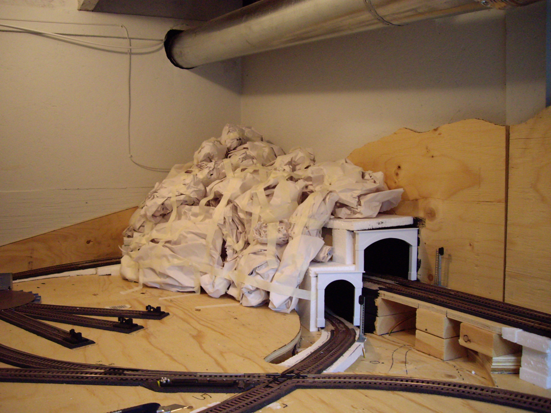 Crumpled paper balls being placed on top of a foam tunnel structure to form a mountain shape