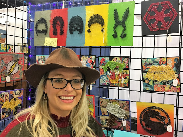 Jessica Greer standing by her string artwork inspired by Bob's Burgers.