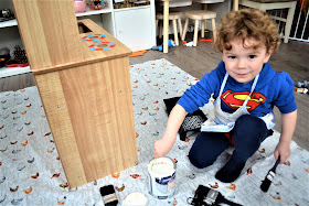 boy painting play kitchen