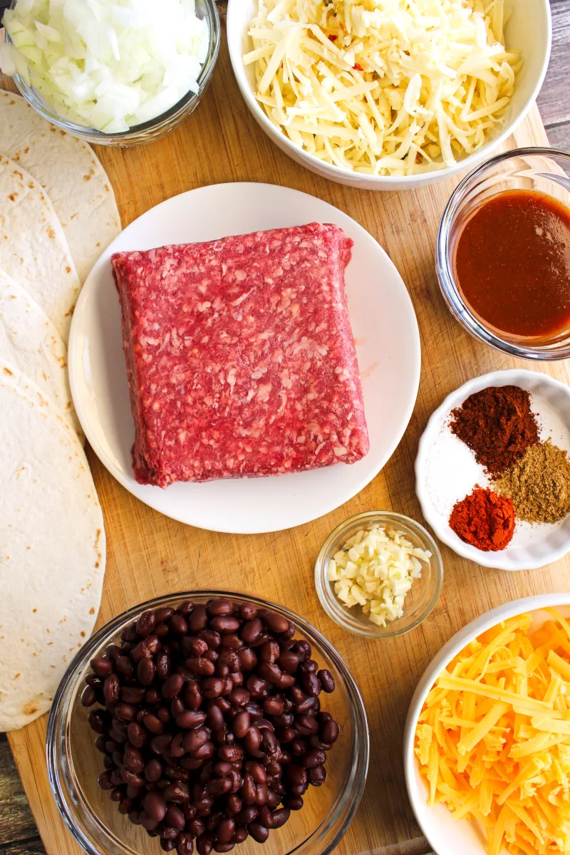 Top view of beef and bean ingredients on a wooden cutting board.