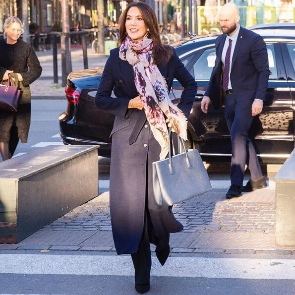 Crown Princess Mary wore a trench coat by Fonnesbech, and high-heel boots by Pura Lopez, and gold earrings by Marianne Dulong. Prada Saffiano bag