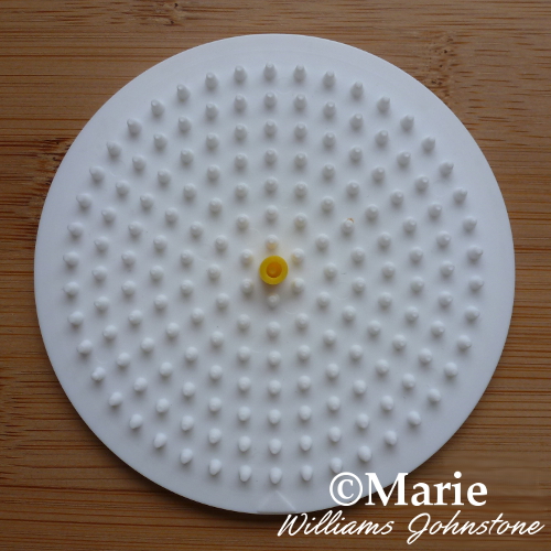 Yellow bead in the middle of a circle pegboard