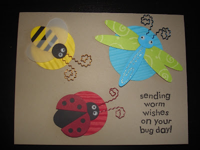 Kraft card with three dimensional bug stickers (bumblebee, dragonfly and ladybug). Each bug is layered on a coordinating punched circle.