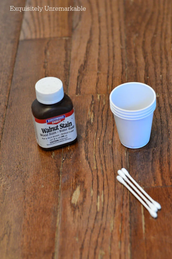 Walnut Stain Wood Stain on floor with a cup and q tips