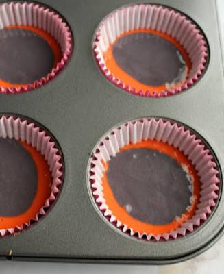 pink and purple cupcake batter in cupcake liners in tin