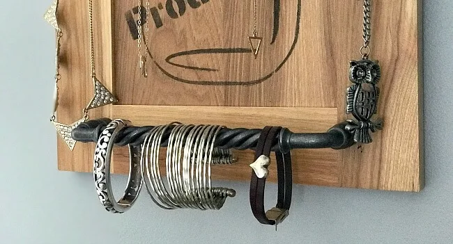jewelry hanging from a bar on a cabinet door.