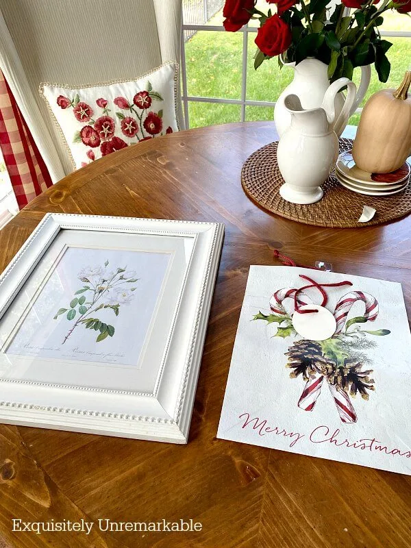 White picture frame and Christmas gift bag on table