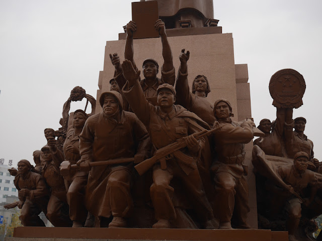 figures surrounding the Mao Zedong statue in Shenyang, China