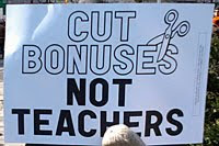 sign saying cut bonus not teachers