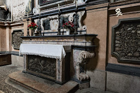 Altar de San Bernardino alle Ossa, lleno de huesos de diferentes partes del cuerpo, sin aparente orden de colocación.
